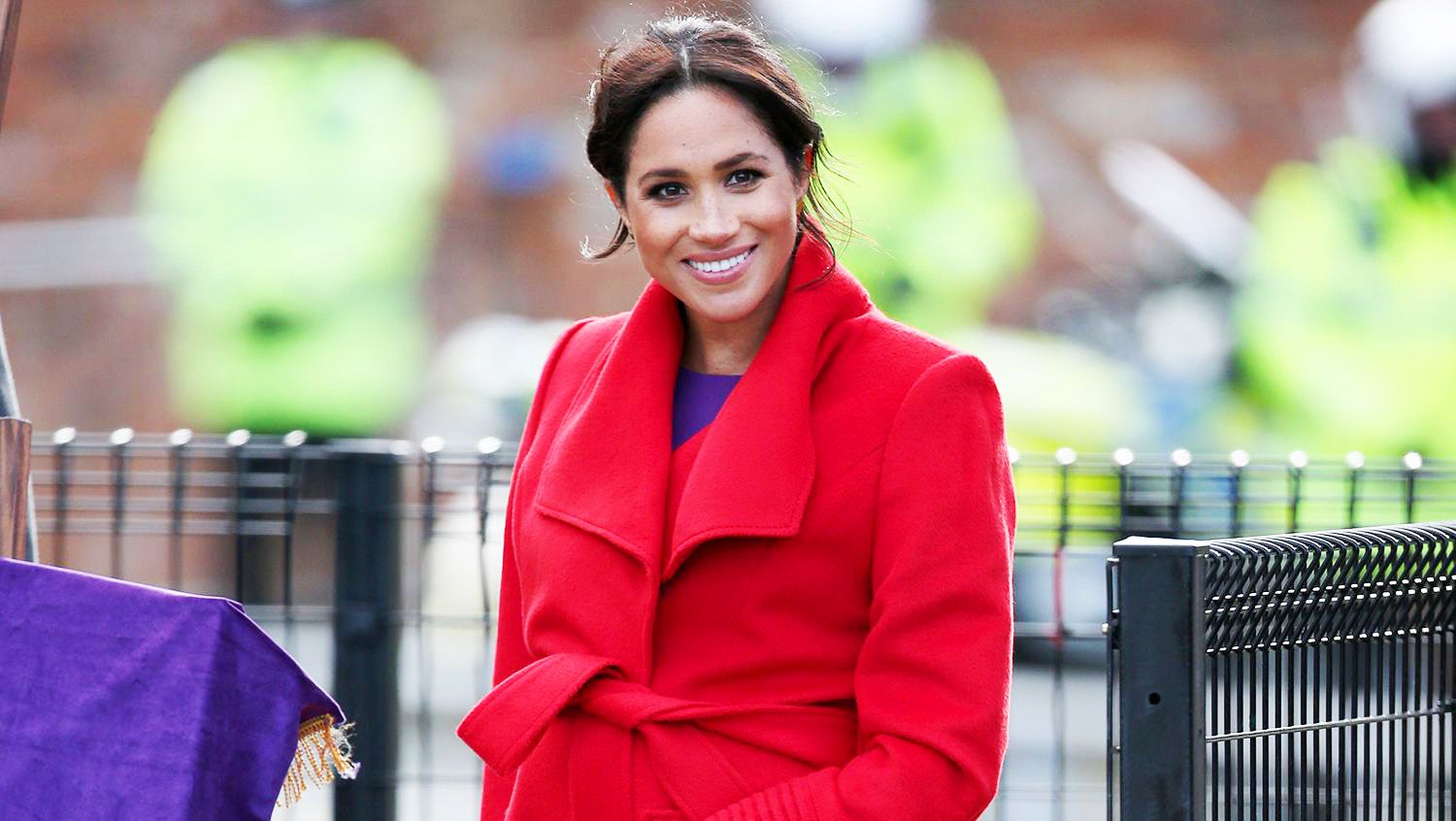 Meghan Markle s Birkenhead Visit Outfit was Her Brightest Yet With a Bold Purple Dress and Contrasting Red Coat Marie Claire