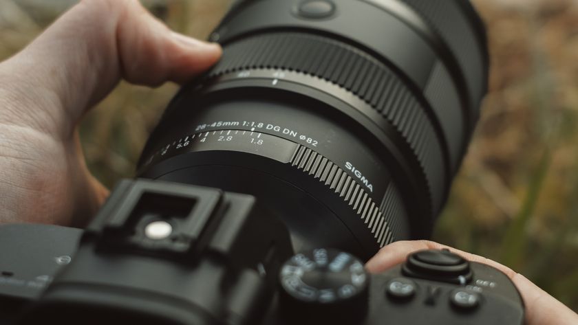 Sigma 28-45mm F1.8 lens mounted on a Sony camera being held by a photographer 