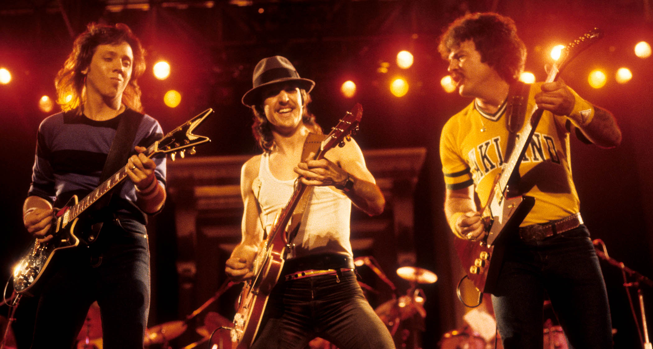(from left) John McFee, Pat Simmons, and Tom Johnston of The Doobie Brothers perform onstage in 1982