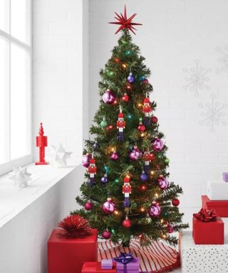 A Christmas tree in a living room with red presents and ornaments