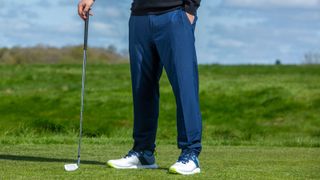 A golfer wears the Original Penguin Performance Golf Pant in blue