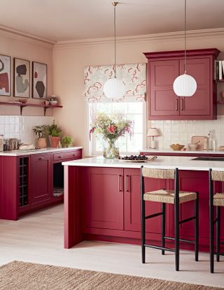 pink kitchen with red kitchen cabinets by Kitchen Makers