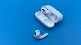 AirPods Pro with on earbud in the charging case and one outside.