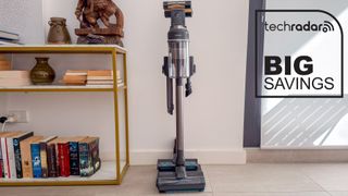 Samsung Jet 95S cordless vacuum with accessories on its stand beside a bookshelf