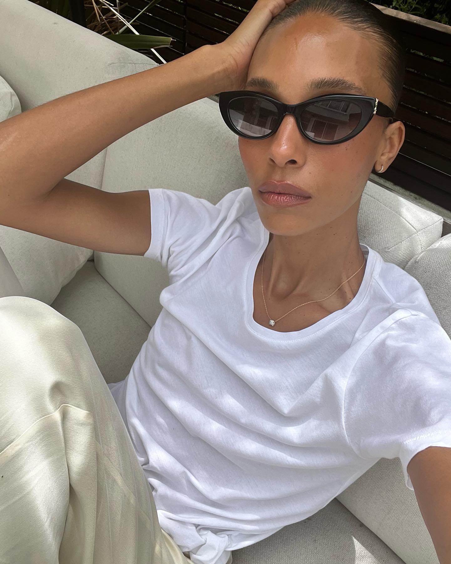 tylynn wears a white tshirt and linen trousers
