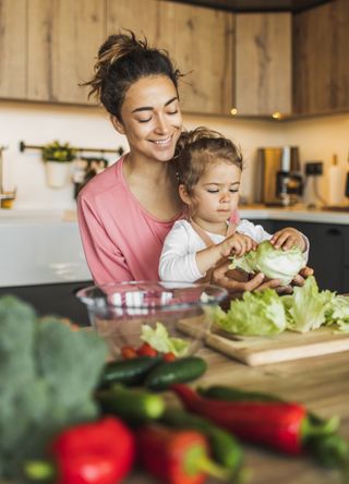 Woman making a salad with a child