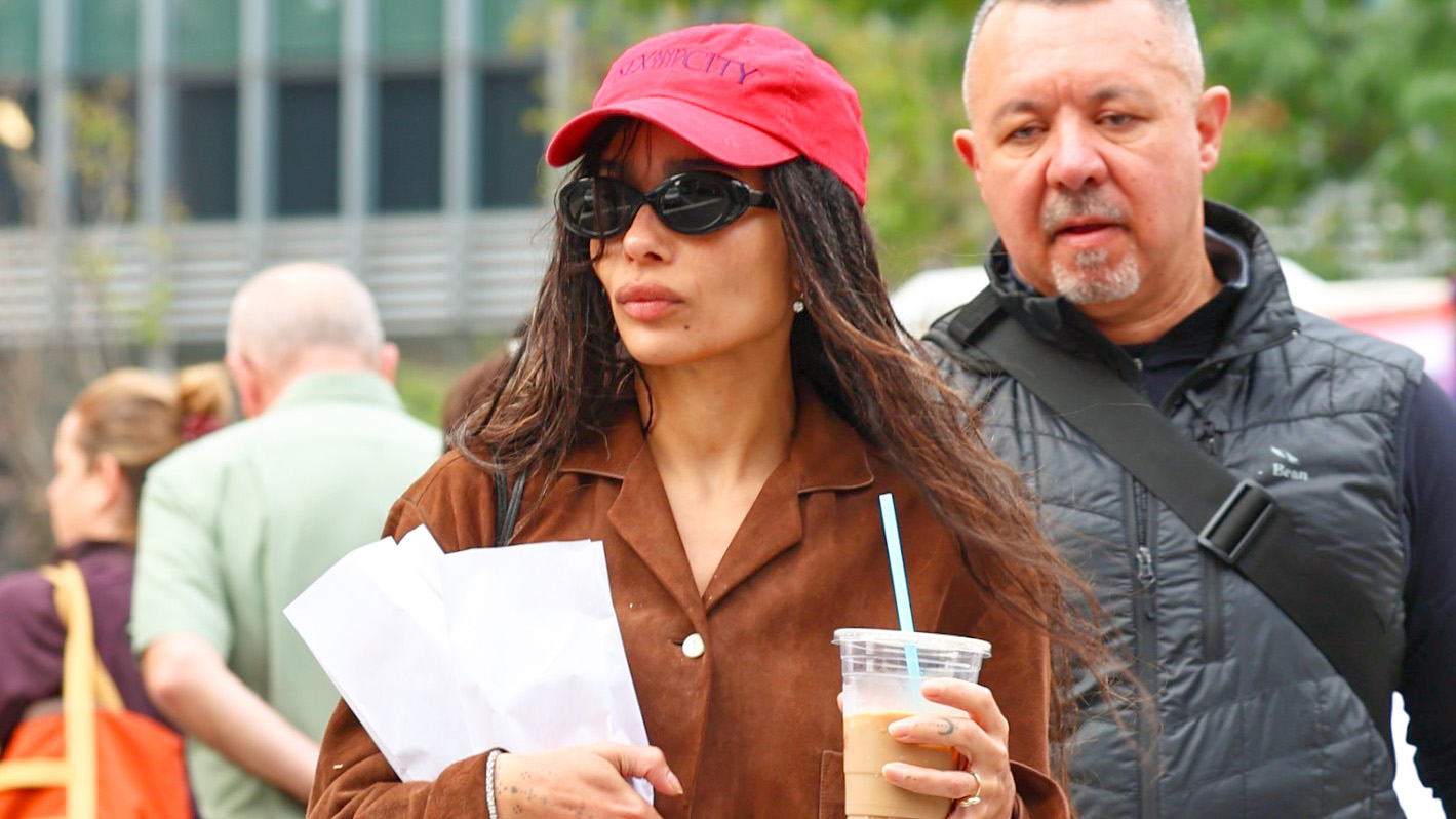 Zo&euml; Kravitz wearing a red baseball cap, brown suede jacket, micro shorts, and ballet pumps in NYC