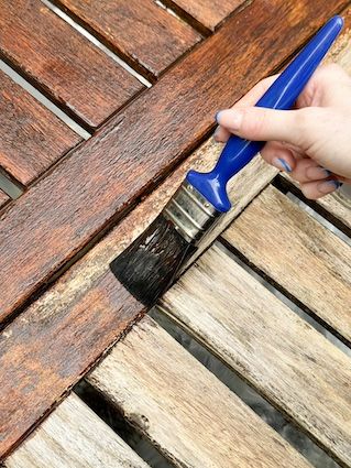 someone sealing a weathered teak outdoor furniture