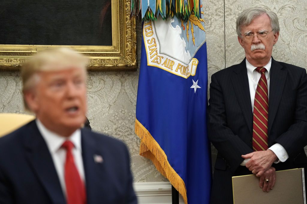 White House National Security Advisor John Bolton (R) listens to U.S. President Donald Trump as he and Dutch Prime Minister Mark Rutte talk to reporters in the Oval Office at the White House 