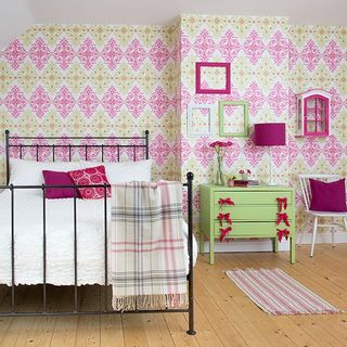 bedroom with pink wallpaper and wooden floor