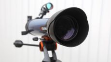 a telescope in front of a white fence