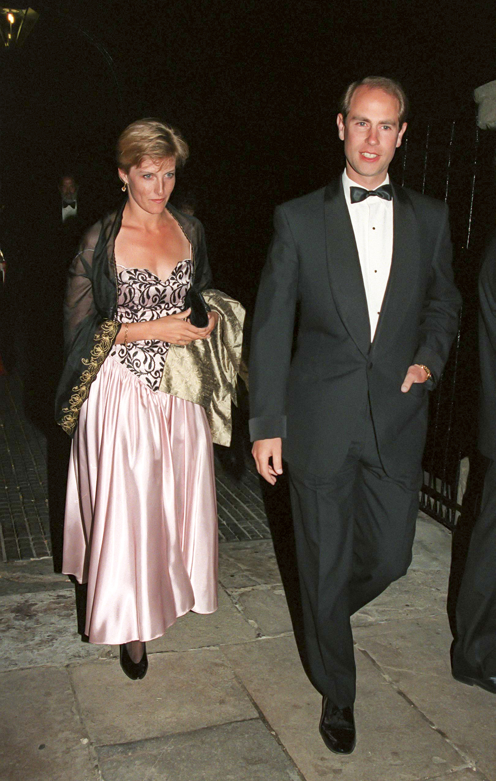 Duchess Sophie wearing a pink gown walking behind Prince Edward in a tux