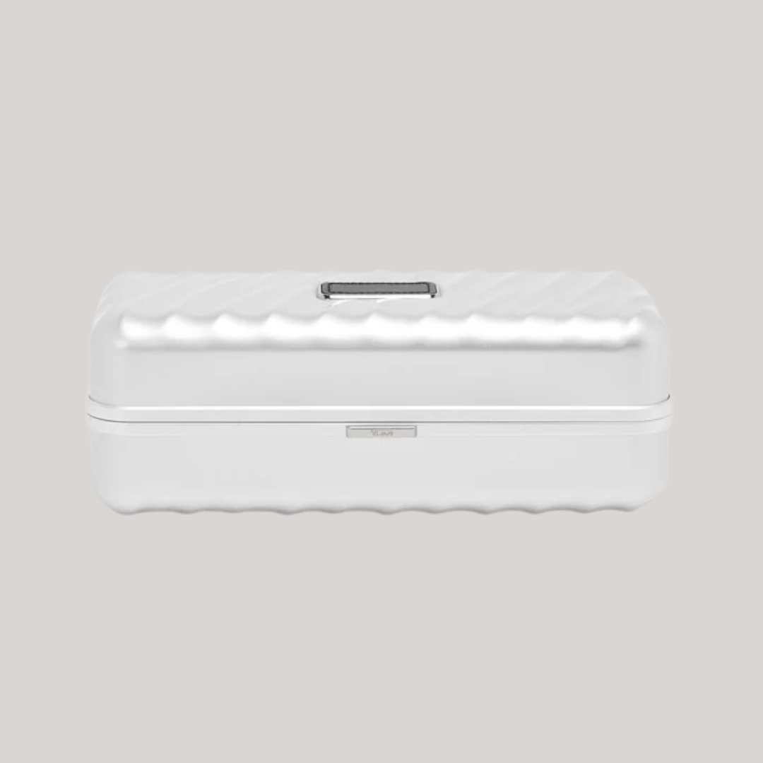 A silver-clad watch travel case with darker detailing and a wavy, textural surface sits against a gray background.