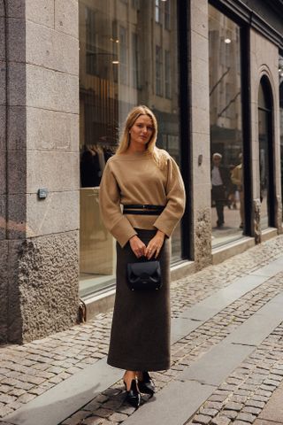 woman wearing sweater, skirt, and mules