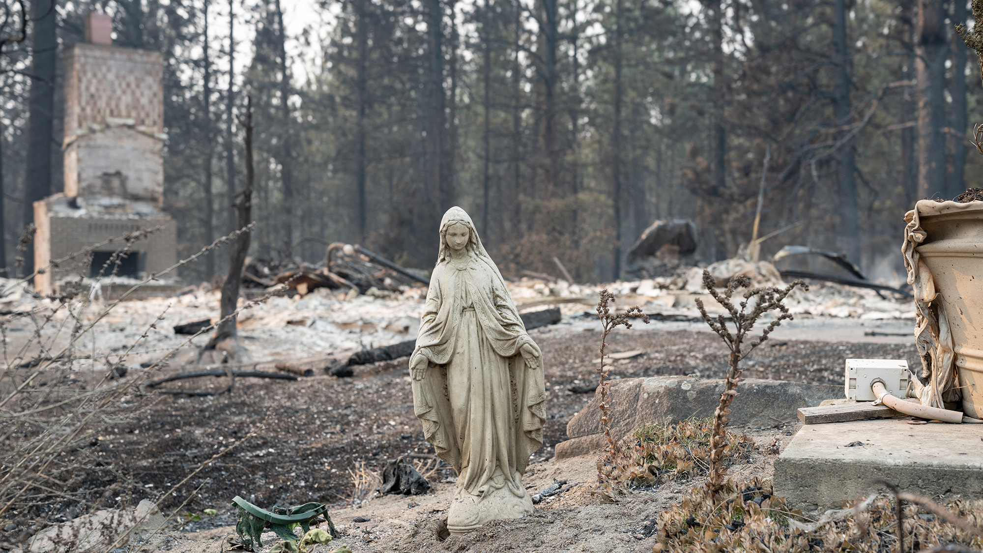 A Virgin Mary statue stands in front of a burned out residential home in the Balboa neighborhood of Spokane, Washington