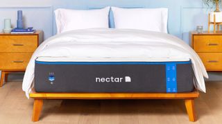 The Nectar Mattress shown on a wooden bed frame and dressed with white pillows and a white comforter