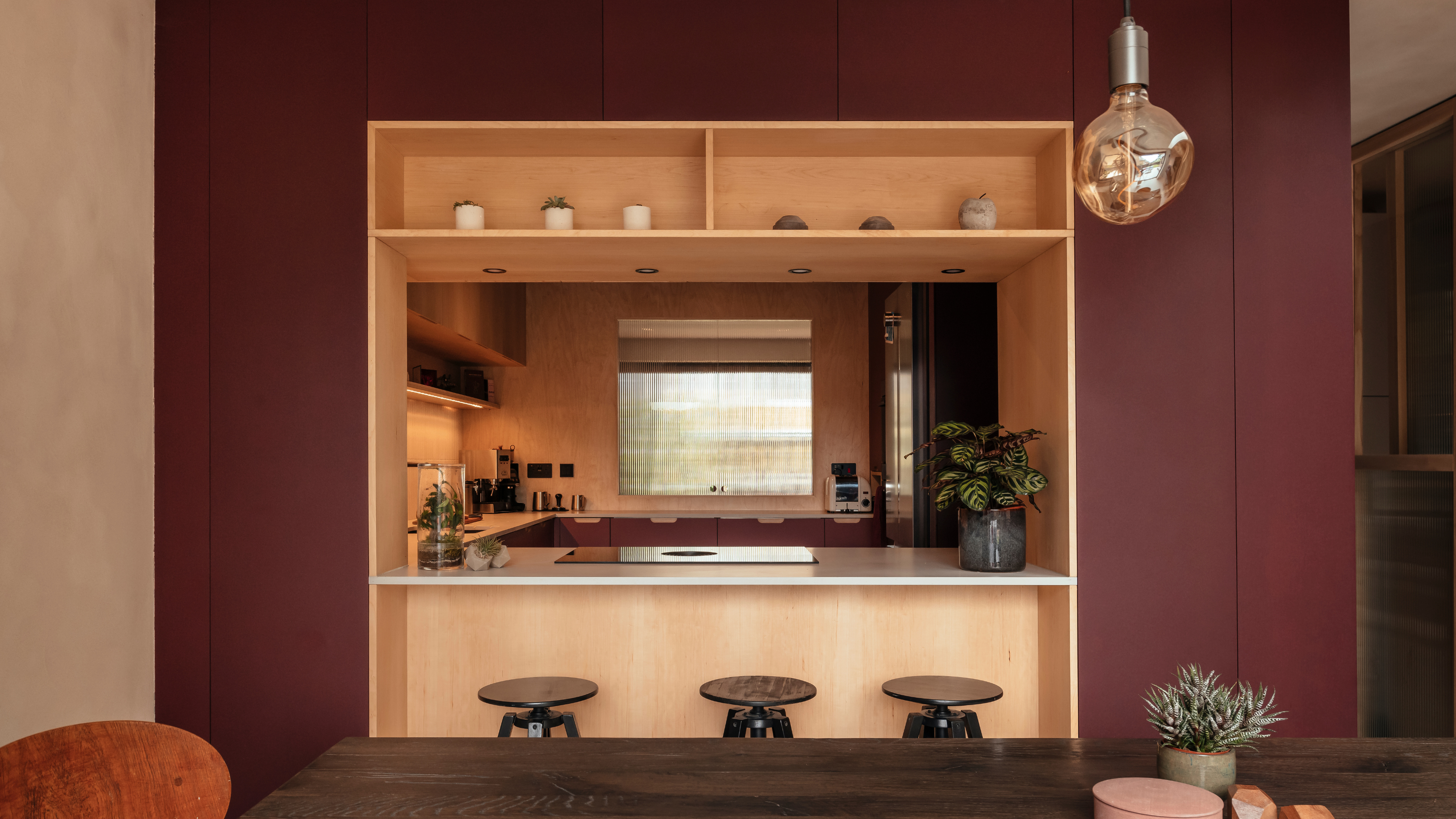 burgundy kitchen with wooden counters and walls