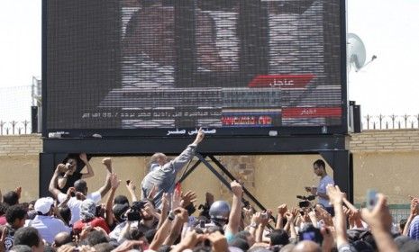 Egyptians watch Mubarak&amp;#039;s trial unfold Wednesday: One lawyer requested a DNA test of the former president, saying the man lying in the hospital bed was not Mubarak.