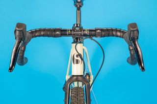 This image of the Stayer Groadinger UG is a front on shot of the handle bars head tube and front wheel mounted in the forks on a blue background.