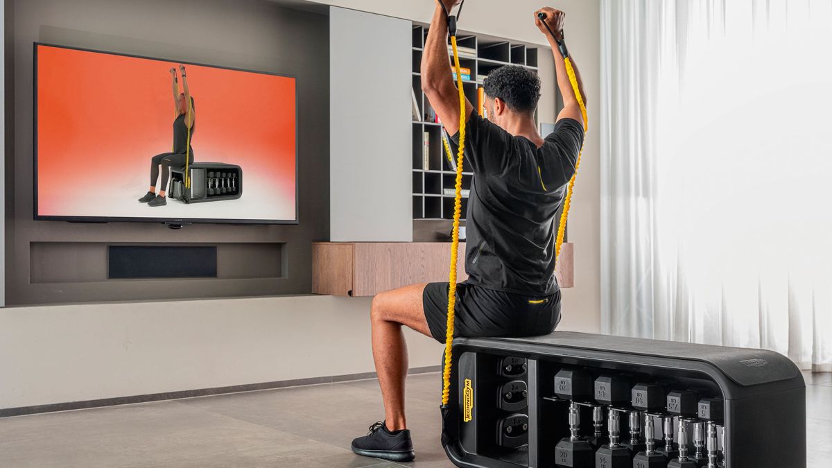 Man working out in front of Samsung TV with TechnoGym app 