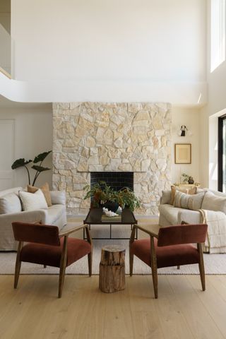 A neutral colored living room with stone fireplace