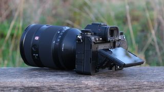 Sony a1 II camera with a Sony FE 28-70mm f/2 GM lens attached on a wooden bench outside