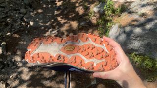 Runner's hand holding the Hoka Speedgoat 6