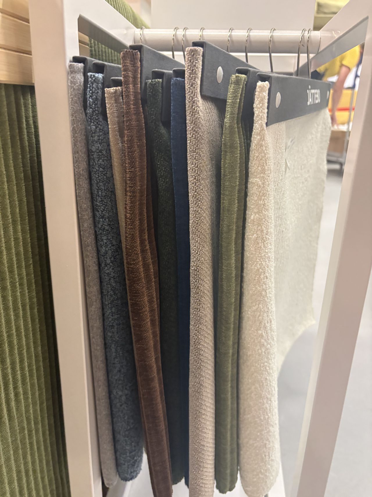 a group of fabric samples hanging on a rod.