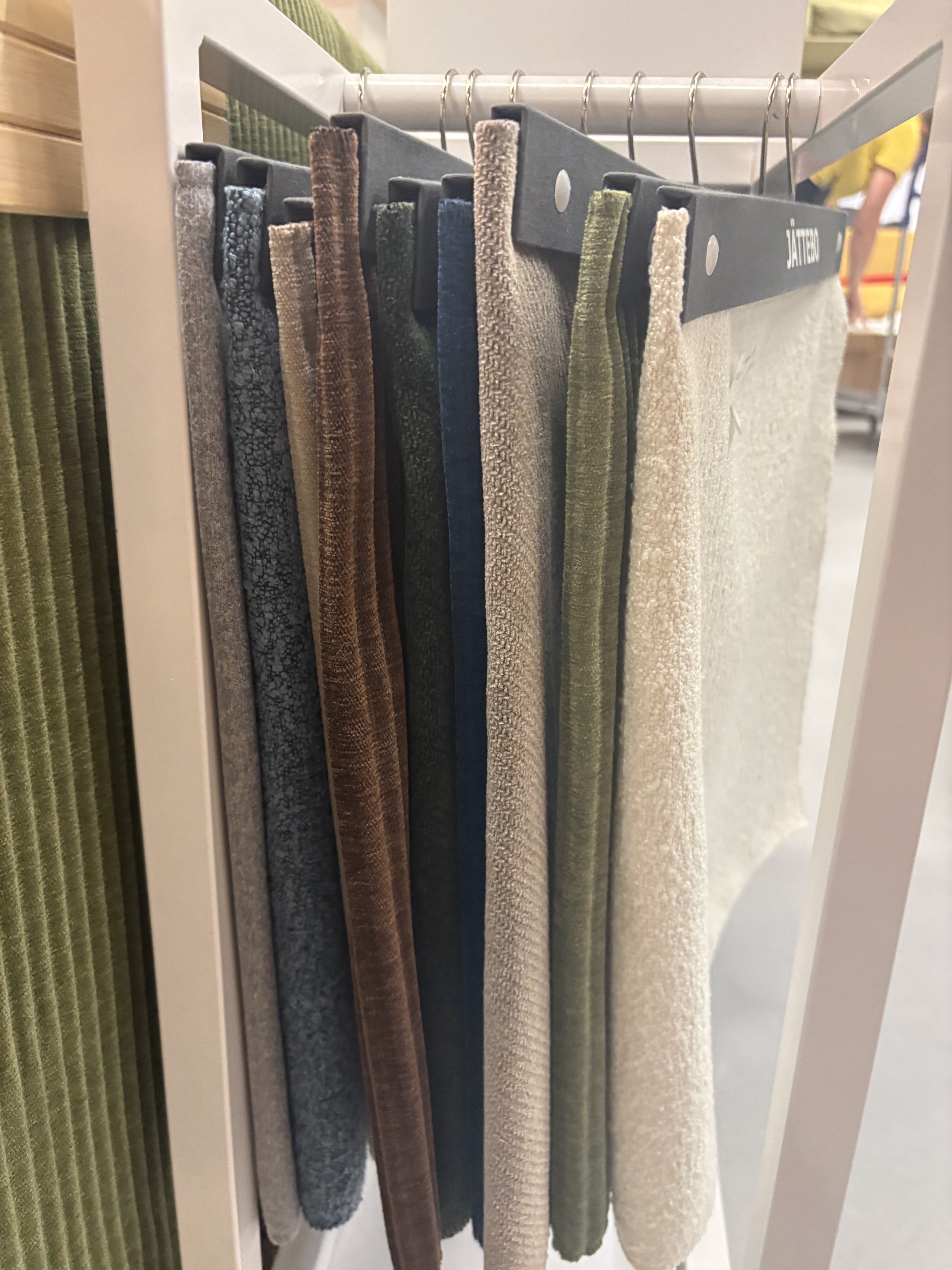 a group of fabric samples hanging on a rod.