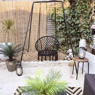 patio makeover with black swing and plants