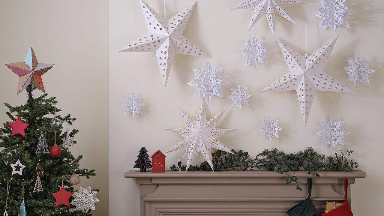 Paper star decorations on a wall above a mantelpiece