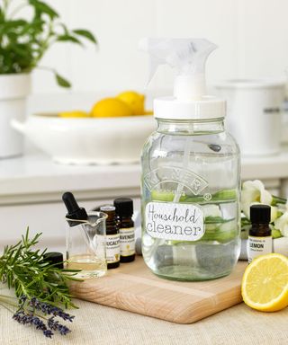 Homemade household cleaner in glass spray bottle on wood board on countertop