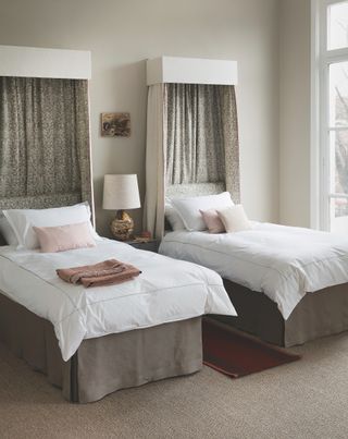 twin beds with canopy above fixed to wall