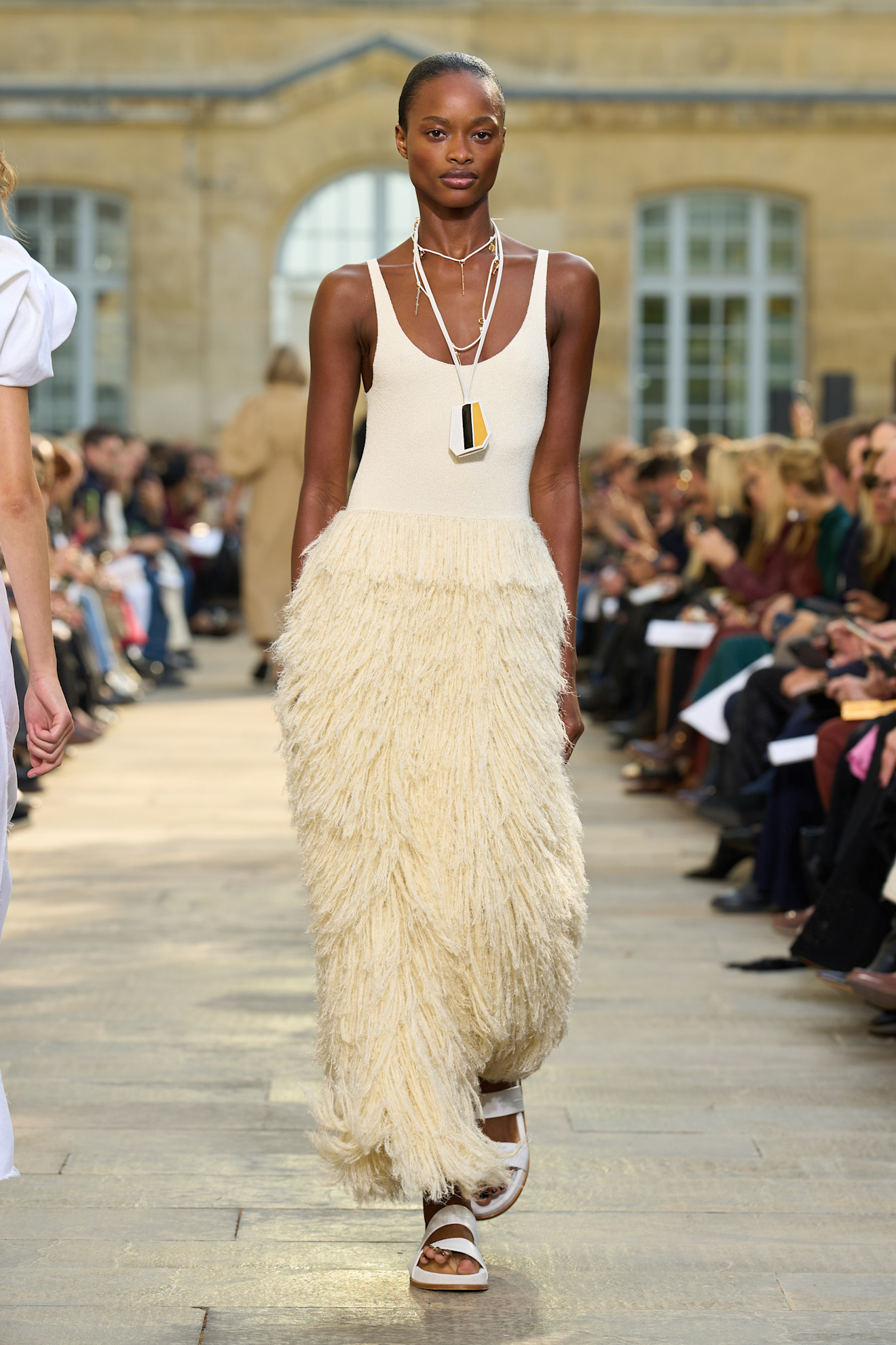 model walks Gabriela Hearst S26 runway wearing fringed cream dress