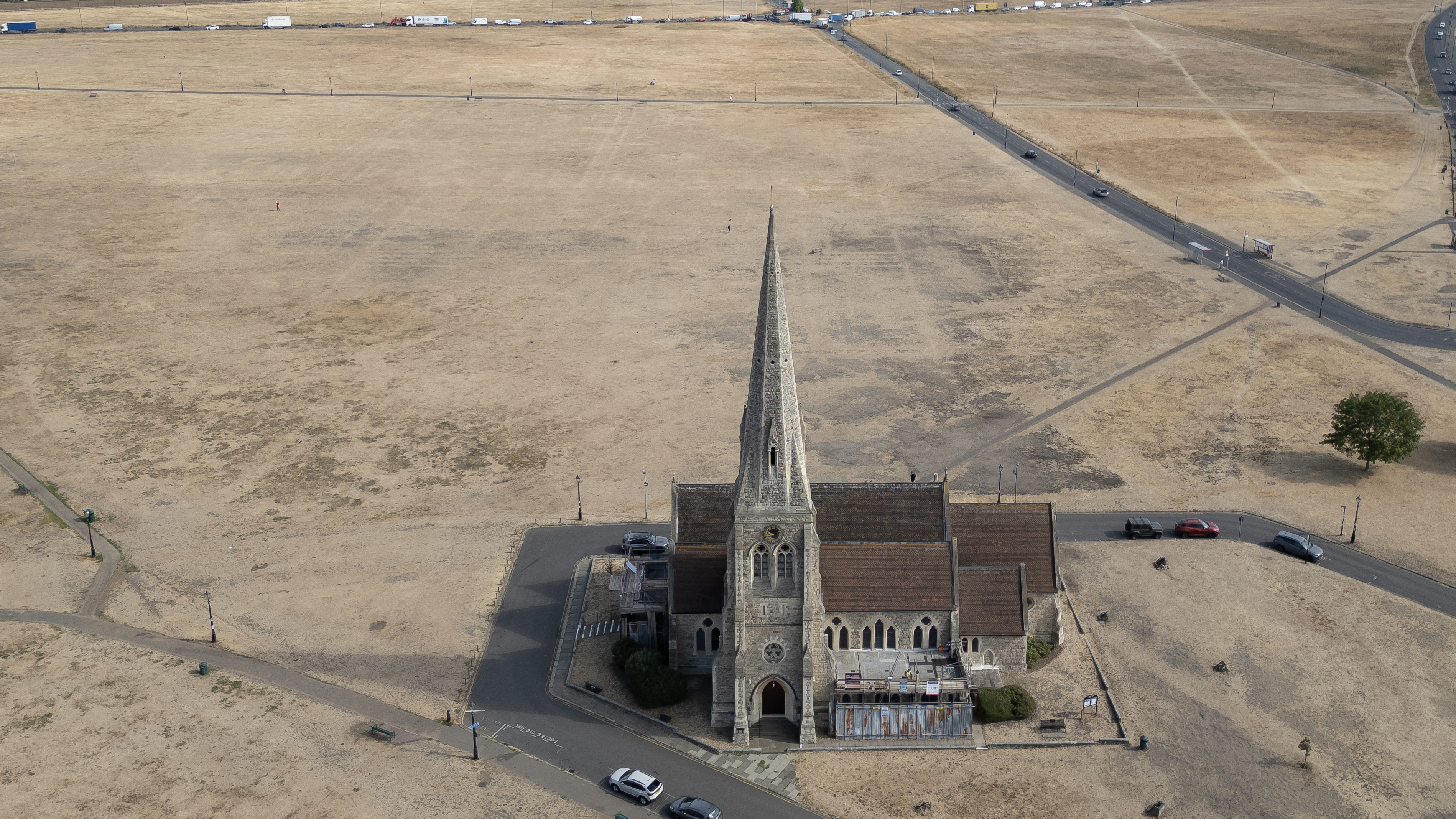 LONDON, UNITED KINGDOM - AUGUST 04: Dried grass surrounds All Saints Church on Blackheath on August 04, 2026 in London, United Kingdom. According to the the National Drought Group, eight areas across southern, central, and eastern England are verging on drought, following a period of "prolonged dry weather," including three heatwaves to hit the region this season. Water companies report seeing a 30% increase in demand for water on the hottest days of the year so far, with more than 20 million households facing hosepipe bans in parts of England and Wales. (Photo by Dan Kitwood/Getty Images)