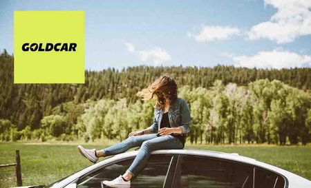 goldcar logo placed top left with a woman sitting on top of a car with her hair covering her face