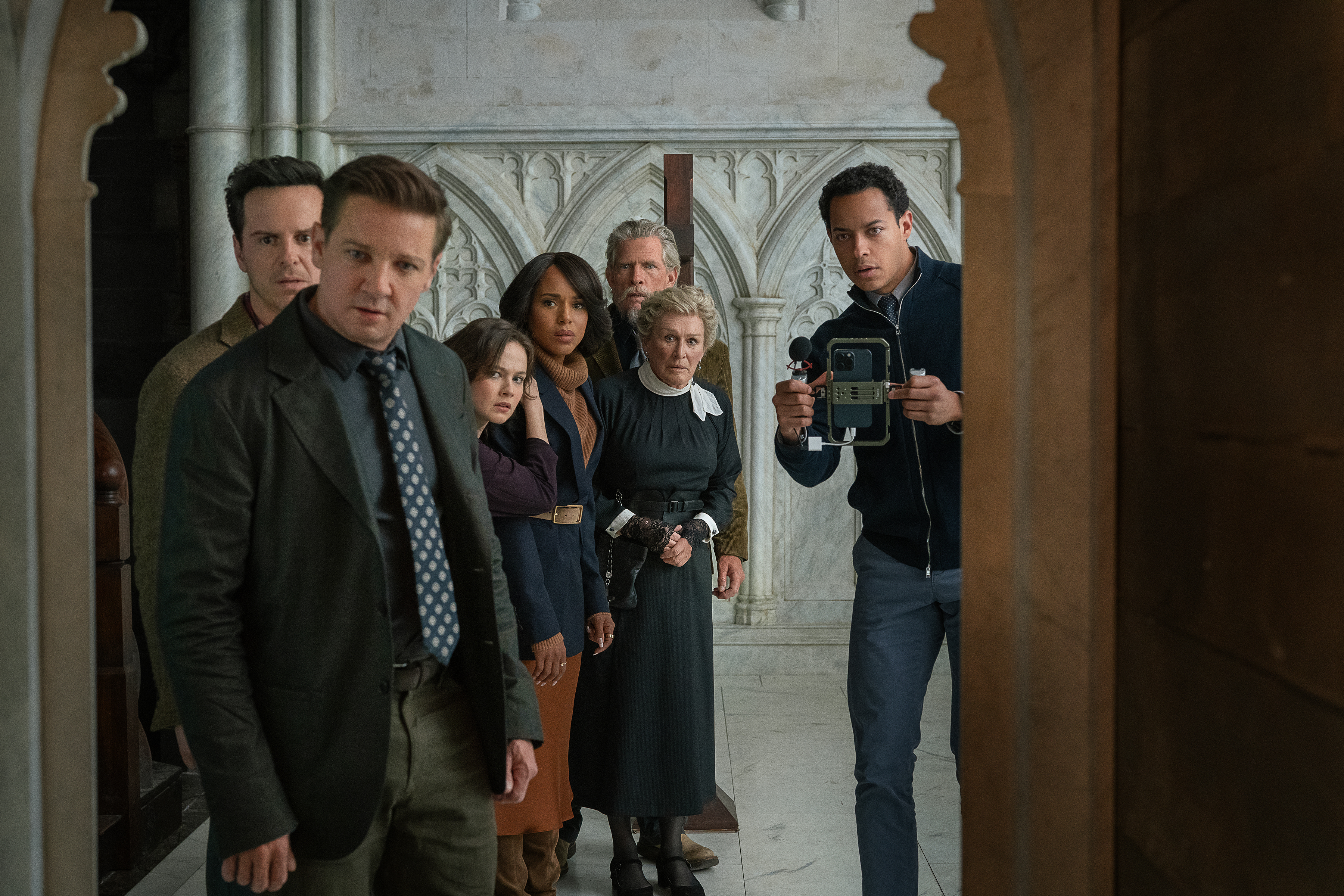 the cast of wake up dead man peer into a church door and take a photo