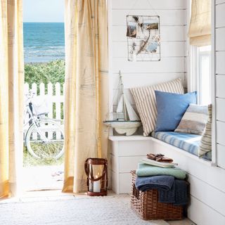 room with coastal view ship print curtain and seating area