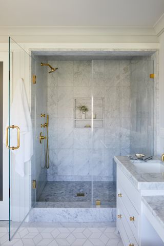 carrara marble bathroom with large marble shower and brass fittings