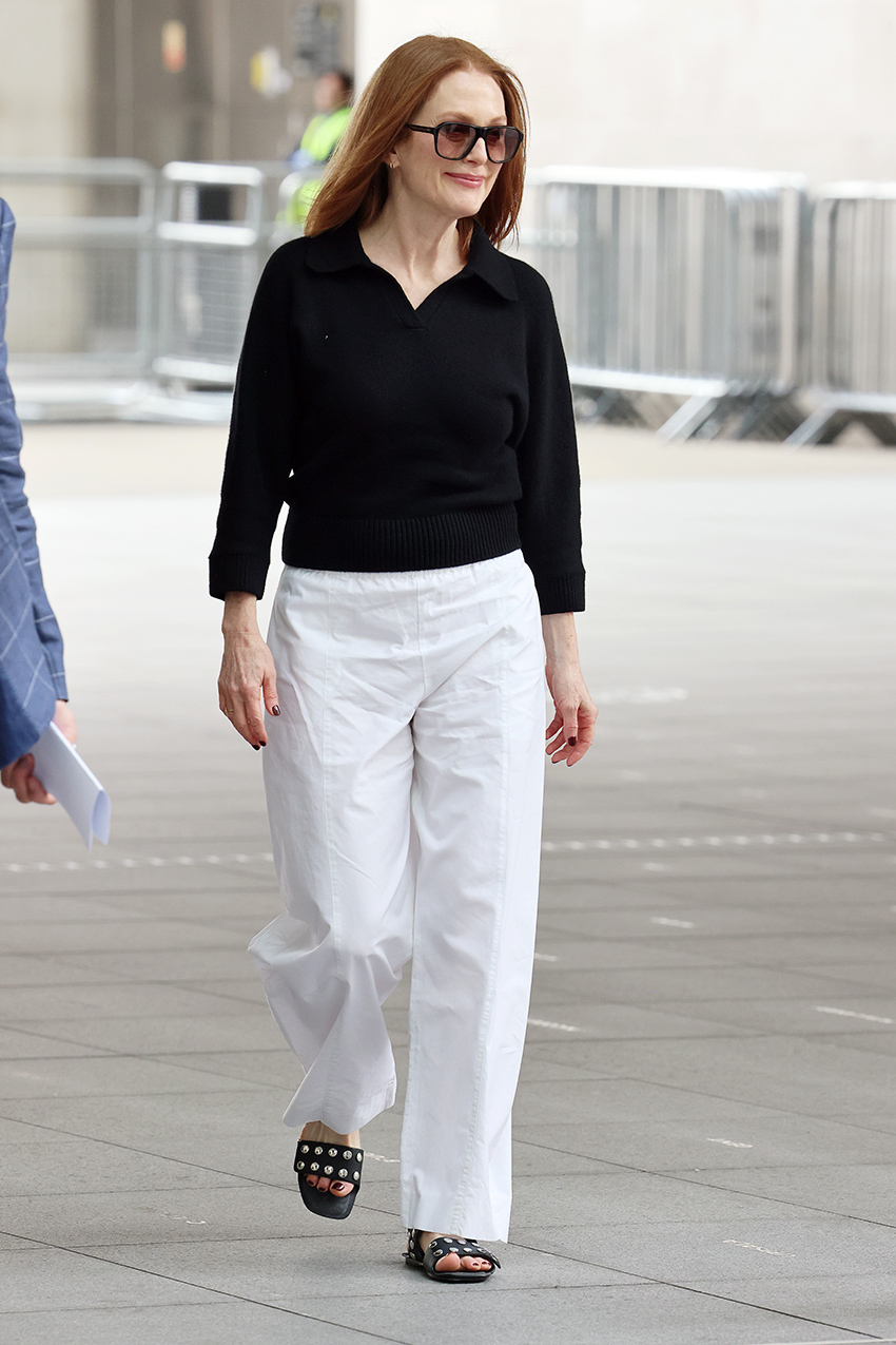 Julianne Moore wearing a black top, white pants, and sunglasses in London