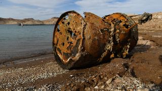 A rusted metal barrel, near the location of where a different barrel was found containing a human body, sits exposed on shore during low water levels due to the western drought at the Lake Mead Marina on the Colorado River in Boulder City, Nevada.