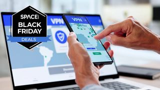 Someone using a smartphone and laptop to access a VPN site, with the space.com black friday deals badge in the top left corner