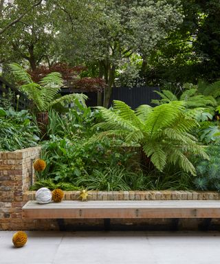 wooden garden bench attached to low brick wall