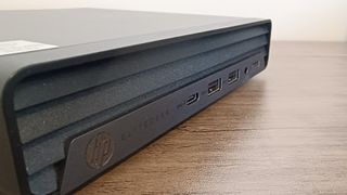 A black compact HP EliteDesk 800 desktop PC sitting on a brown wooden table