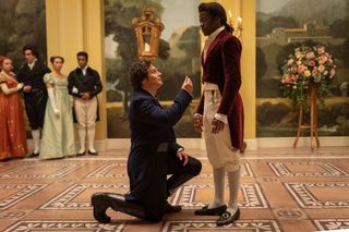 A man on one knee holding a ring up to another man.