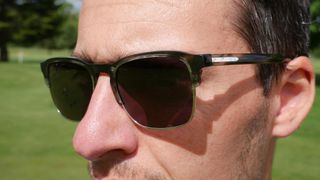 man wearing Vincero The Villa sunglasses out on the golf course