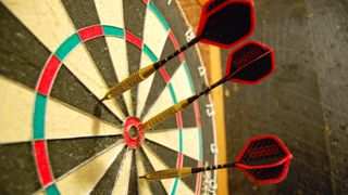 Picture of three darts clusters around the bullseye of a professional dartboard ahead of the 2024 darts world final featuring Luke Littler vs Luke Humphries.
