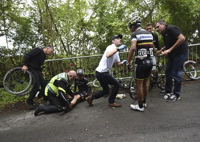 A Rapha Condor rider along with Duber Armando Quintero Artunduaga collide and are helped by the medics