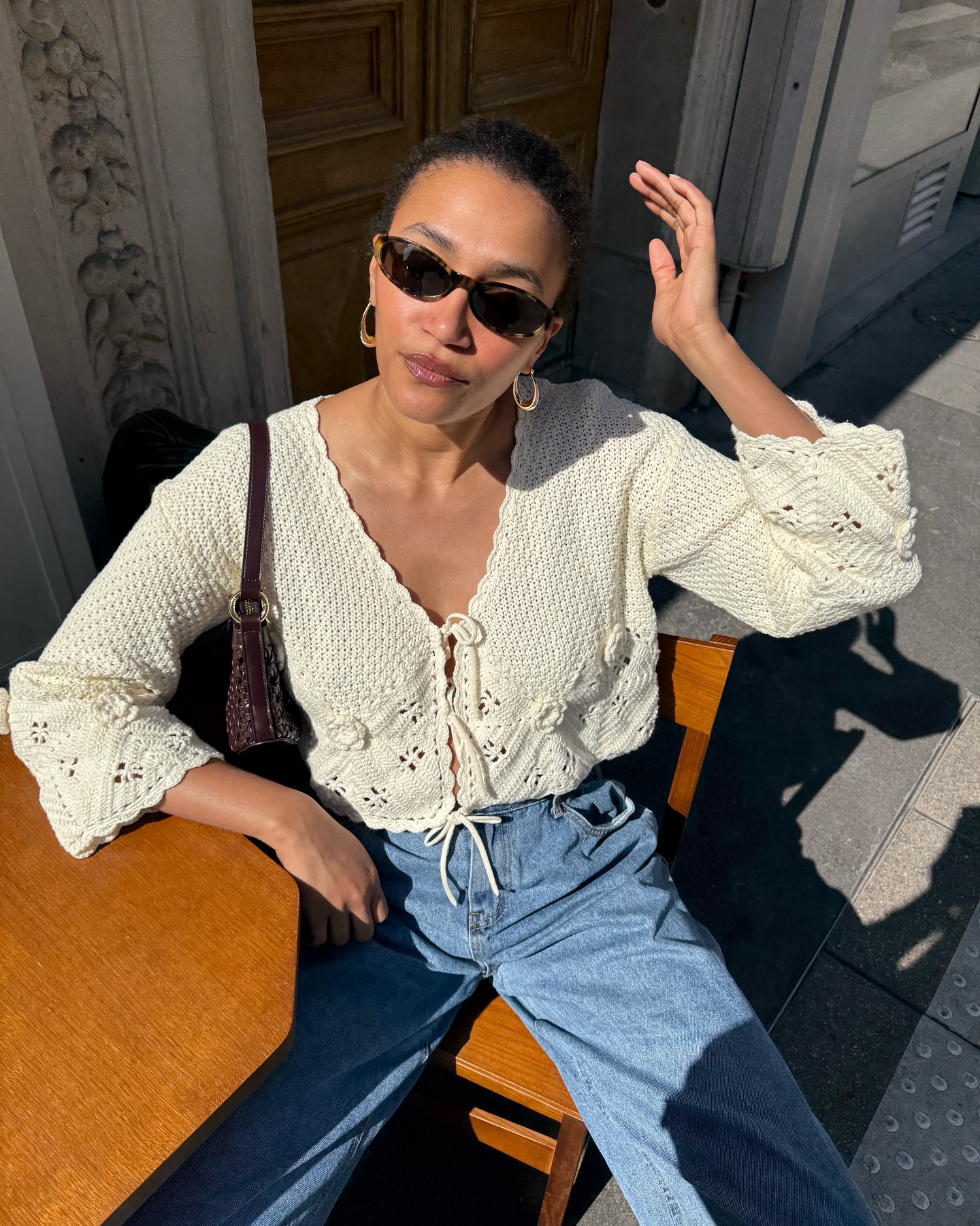 Lena wearing a white crochet blouse and blue jeans