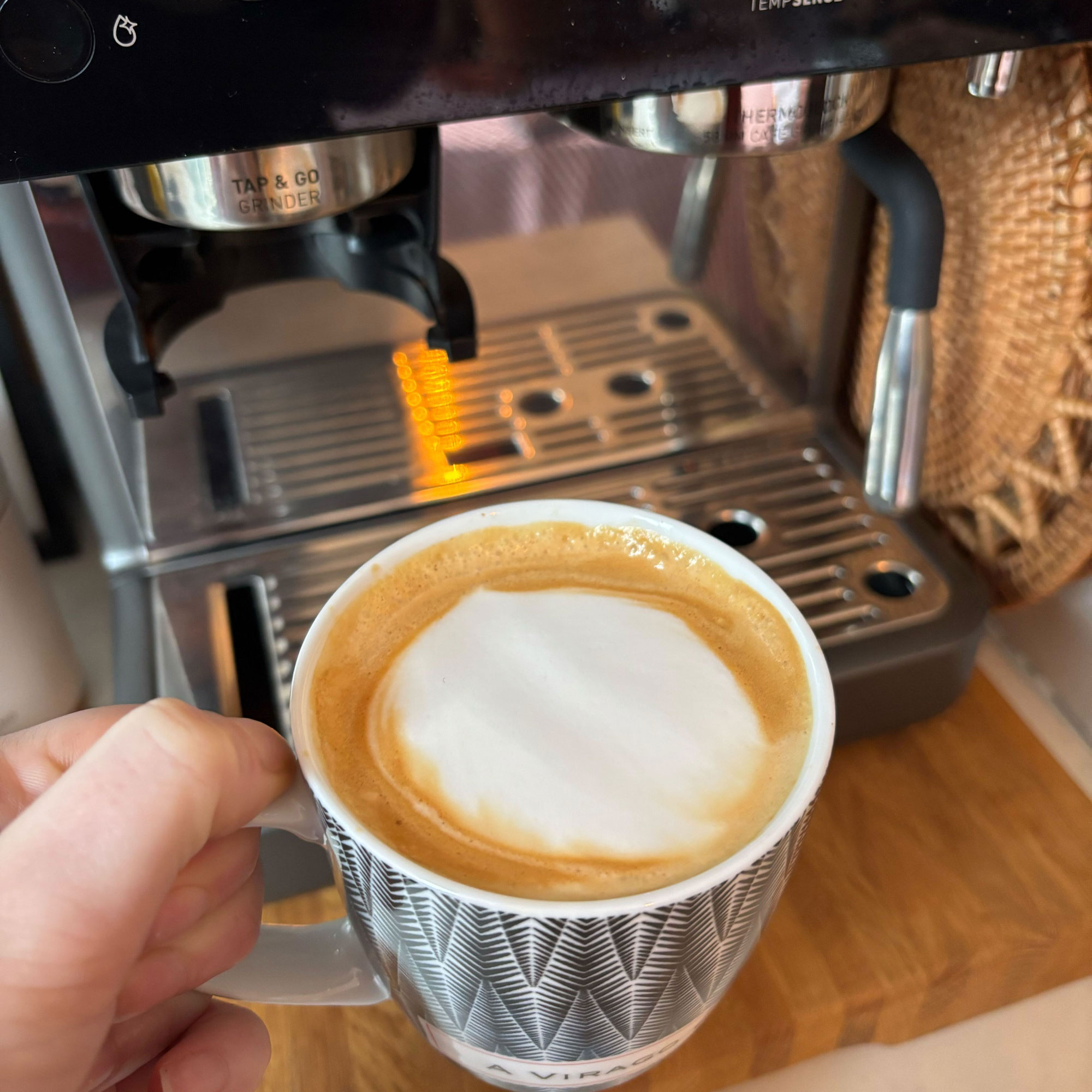 Latte in front of a silver coffee machine